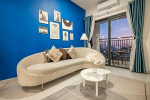 a living room with a couch and a blue wall at Otis Soho Saigon Balcony Apartment in Ho Chi Minh City