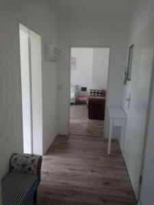 an empty hallway with a chair and a table in a room at ELBENLAND SÄCHSISCHE SCHWEIZ II - Komfortable 2-Raum-Wohnung im Herzen der sächsischen Schweiz in Sebnitz