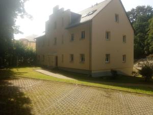 a large white building on the side of a road at ELBENLAND SÄCHSISCHE SCHWEIZ II - Komfortable 2-Raum-Wohnung im Herzen der sächsischen Schweiz in Sebnitz