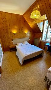 ein Schlafzimmer mit einem großen Bett in einem Holzzimmer in der Unterkunft Villa Prairie Mont-Dore 7 Appartements in Le Mont-Dore