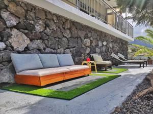 a couch sitting on a sidewalk next to a stone wall at Casa Aloe in El Paso