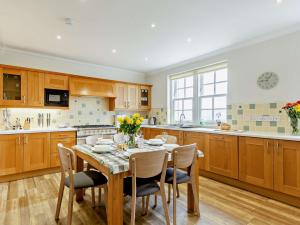 a kitchen with a table and chairs and a kitchen with wooden cabinets at 3 Bed in Conon Bridge CA388 in Cononbridge