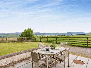 a table and chairs on a patio with a fence at 3 Bed in Conon Bridge CA388 in Cononbridge