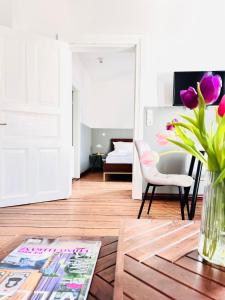 uma sala de estar com um vaso de flores sobre uma mesa em Wellenreiter em Tating