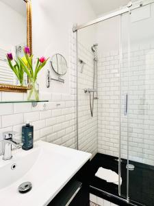 a white bathroom with a sink and a glass shower at Wellenreiter in Tating