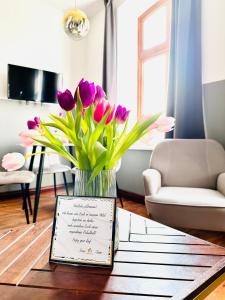un vase de tulipes violets sur une table dans le salon dans l'établissement Wellenreiter, à Tating