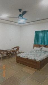 1 dormitorio con 1 cama, 2 sillas y mesa en Rama Farms, en Sangamner