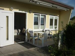 eine Terrasse mit Stühlen und einem Tisch auf einem Haus in der Unterkunft Bungalow Oase der Ruhe in Lobbe