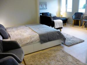 ein Schlafzimmer mit einem Bett und einer Couch in der Unterkunft Bungalow Oase der Ruhe in Lobbe