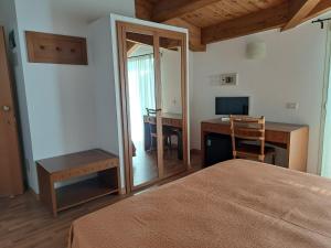 1 dormitorio con 1 cama y escritorio con ordenador en Hotel Escorial en Cervia