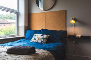 Stunning Apartment Derby Free Wi-Fi & Parking في ديربي: غرفة نوم مع سرير ومرآة على الحائط