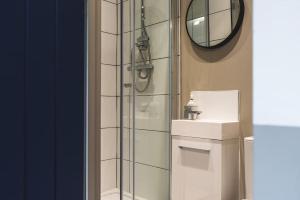 a bathroom with a shower and a sink and a mirror at Stunning Apartment Derby Free Wi-Fi & Parking in Derby