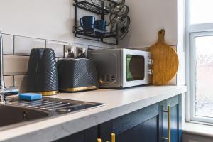 a kitchen counter with a microwave and a stove at Stunning Apartment Derby Free Wi-Fi & Parking in Derby
