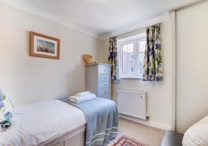 a small bedroom with a bed and a window at 7 Sea Mews in Cromer