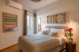 a bedroom with a large bed and a window at Touching Acropolis - Quiet & Elegant 1-Bdr Apt in Athens