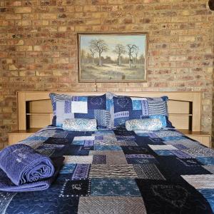 een slaapkamer met een bed met een quilt bij Villa Dachie in Rayton