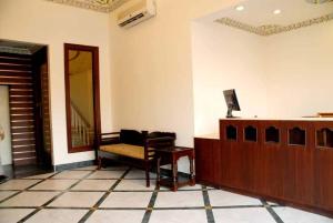 a living room with a bench and a mirror at Hotel Glitz Jaipur in Jaipur
