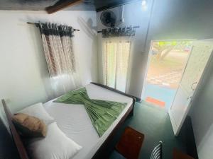 a small room with a bed and a window at Ima Villa Sigiriya in Sigiriya