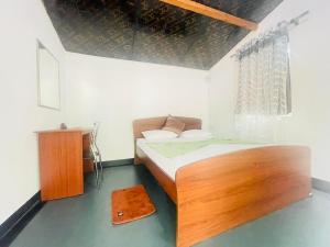 a small bedroom with a wooden bed and a window at Ima Villa Sigiriya in Sigiriya