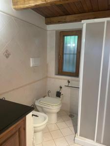 La salle de bains blanche est pourvue de toilettes et d'une fenêtre. dans l'établissement bel vedere salicaio 8, à Salerne