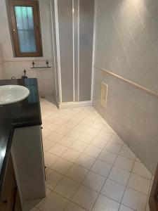 La salle de bains est pourvue de carrelage blanc, d'un lavabo et d'une douche. dans l'établissement bel vedere salicaio 8, à Salerne