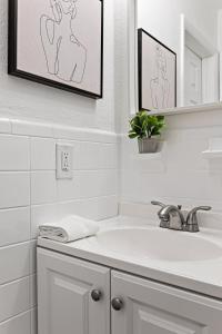 a white bathroom with a sink and a mirror at Stylish 2 BR Condo - Free Parking on Premises in Fort Lauderdale