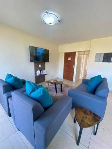 a living room with two blue couches and a table at Oceanic 2 Bedroom Apartment - Ocean and Park View - Self-Catering in Durban