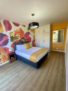 een slaapkamer met een bed met een schilderij aan de muur bij The Oceanic 2 Bedroom with Ocean View - Self Catering Apartment in Durban