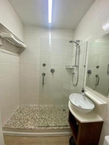 een badkamer met een douche, een wastafel en een spiegel bij The Oceanic 2 Bedroom with Ocean View - Self Catering Apartment in Durban
