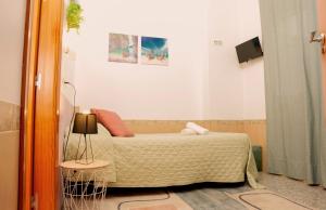 1 dormitorio con 1 cama y 1 mesa con lámpara en ALOJAMIENTO Aire De Los Alcores, en El Viso del Alcor