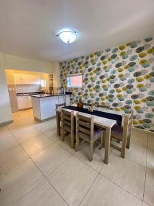 a dining room with a table and chairs and a kitchen at The Oceanic 2 Bedroom with Ocean View - Self Catering Apartment in Durban