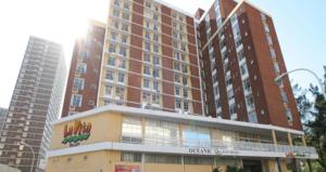 een groot gebouw met een hotel ervoor bij The Oceanic 2 Bedroom with Ocean View - Self Catering Apartment in Durban