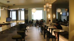 un gruppo di persone sedute ai tavoli di un ristorante di Gspot Hostels & Love Triangles Pizzeria a Lisbona Altre 14 foto