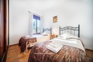 sypialnia z dwoma łóżkami i ręcznikami na nich w obiekcie Impresionante Casa de Campo, Alora, Málaga w Maladze