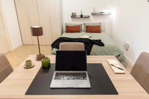 einen Laptop auf einem Tisch in einem Zimmer mit einem Bett in der Unterkunft KAMCHŪ RESIDENCE - VIA DEI LAGHI: APT #R2 in Ciampino