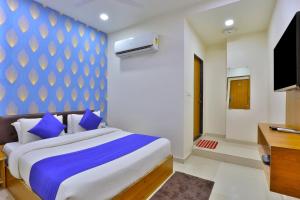 a bedroom with a bed with a blue and white wall at Hotel Shivaay in Ahmedabad