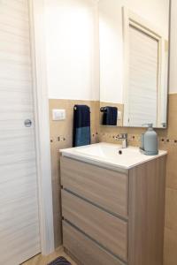ein Bad mit einem Waschbecken und einem Spiegel in der Unterkunft KAMCHŪ RESIDENCE - VIA DEI LAGHI: APT #R2 in Ciampino