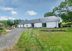 a white barn with a grass yard in front of it at South Cuma in Drewsteignton