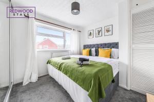 Un dormitorio con una cama con una manta verde. en 3 Bedroom House x2 FREE Parking Netflix By REDWOOD STAYS, en Camberley