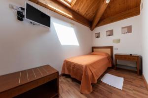 a bedroom with a bed and a flat screen tv at Hotel Escorial in Cervia