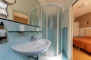 a bathroom with a sink and a shower at Hotel Escorial in Cervia