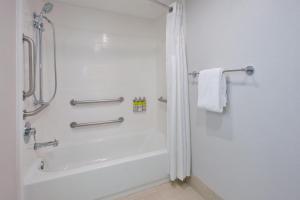 y baño blanco con ducha y bañera. en Holiday Inn Express Fairfax-Arlington Boulevard, an IHG Hotel en Fairfax