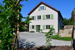 uma grande casa branca com persianas verdes em Domizil Eutschützblick em Bannewitz
