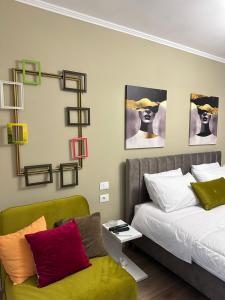 sypialnia z łóżkiem i zieloną kanapą w obiekcie Horta's home w Tiranie