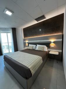 1 dormitorio con cama grande y ventana grande en Mediterranea Hotel & Convention Center, en Salerno