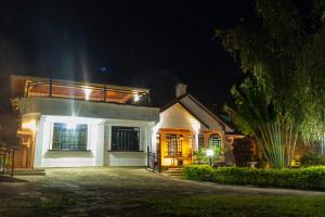 a white house with a balcony at night at Elevate by African Manor in Bungoma