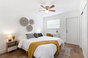 a white bedroom with a bed and a ceiling fan at Bright and Spacious 2 BR Apartment in Fort Lauderdale