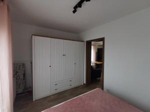 a bedroom with a white closet and a bed at Sunny Apartament in Darłowo