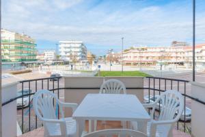 d'une table et de chaises sur un balcon avec vue sur la ville. dans l'établissement Residence Playa Grande Immobiliare Pacella, à Lido di Jesolo