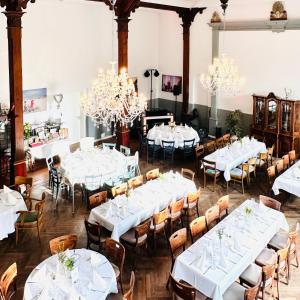 a dining room with white tables and chairs and chandeliers at Wellenreiter in Tating